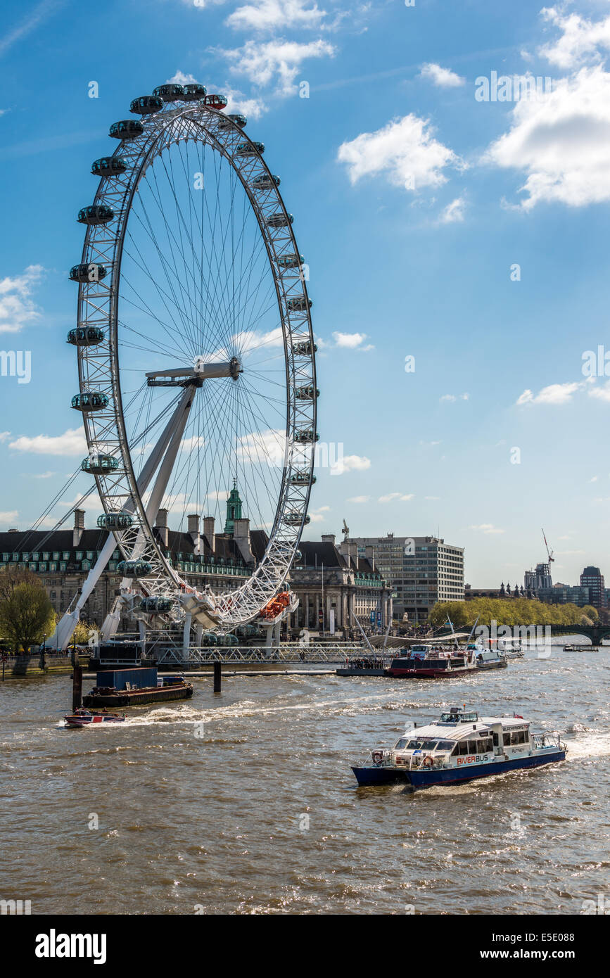 Une croisière sur le fleuve passe par le London Eye, une grande roue sur la rive sud de la Tamise à Londres Banque D'Images
