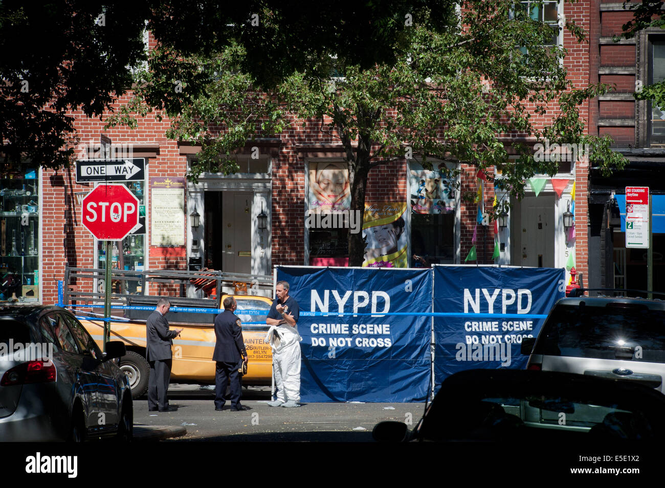 Manhattan, New York, USA. 28 juillet, 2014. Un membre judiciaire NYPD parle avec comme deux détectives U.S. Marshals et un détective du NYPD ont été abattus sur la 4e Rue Ouest près de chez Jones Street lors de la tentative d'arrestation des supposés pédophile Charles Mozdir, tué par balle, lundi, 28 juillet 2014. Credit : Bryan Smith/ZUMA/Alamy Fil Live News Banque D'Images