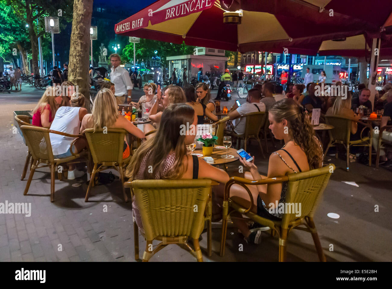 amsterdam, Hollande, pays-Bas, jeunes touristes femmes partageant des boissons sur la terrasse du café place de la ville, trottoir, rue urbaine la nuit, les jeunes, Banque D'Images