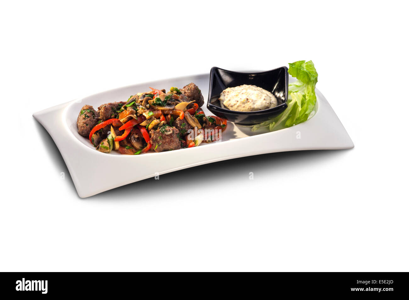 Les boulettes de viande et de légumes sur une assiette décorée avec de la sauce isolated on white Banque D'Images