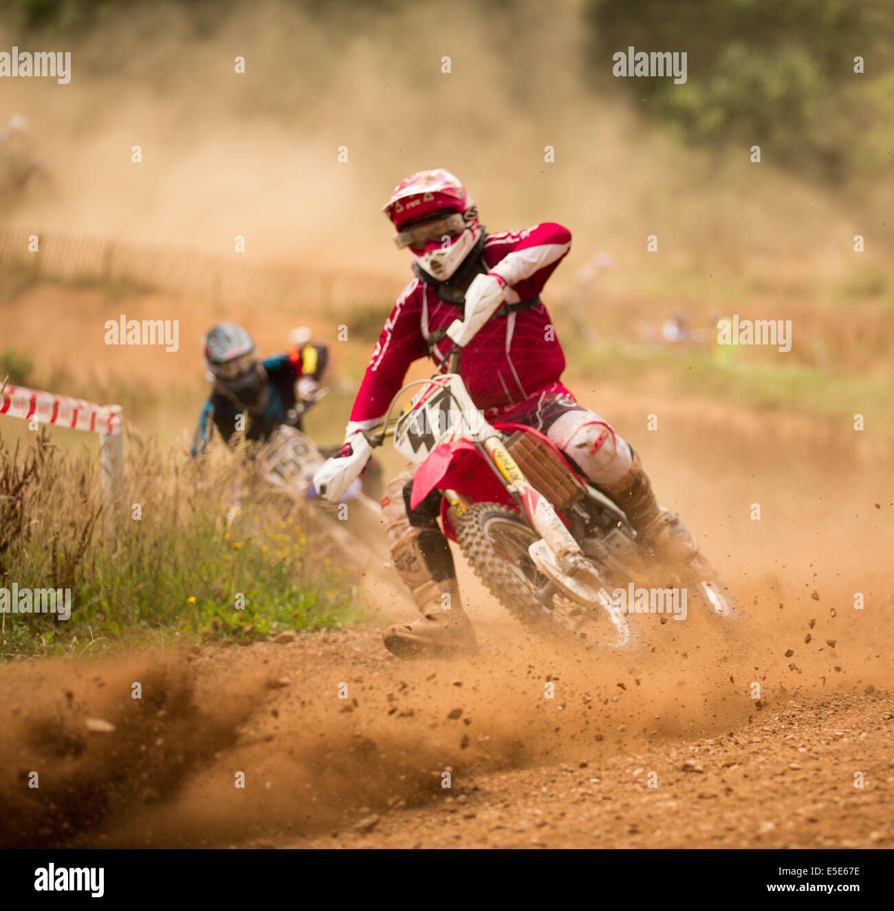 Rider motocross dans la course sur piste poussiéreuse Banque D'Images