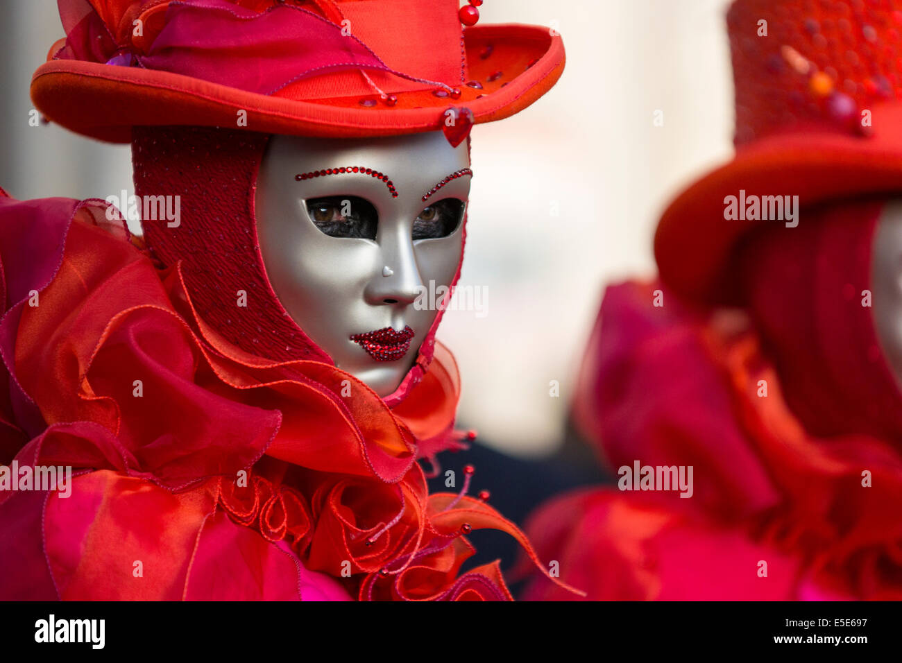 Rouge vif et costumes à froufrous orne une femme en st. la place Saint-Marc à Venise pendant le carnaval. Banque D'Images
