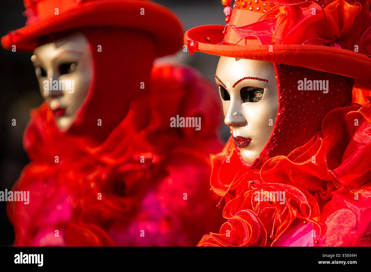 Rouge vif et costumes à froufrous ornent deux femmes à st. la place Saint-Marc à Venise pendant le carnaval. Banque D'Images