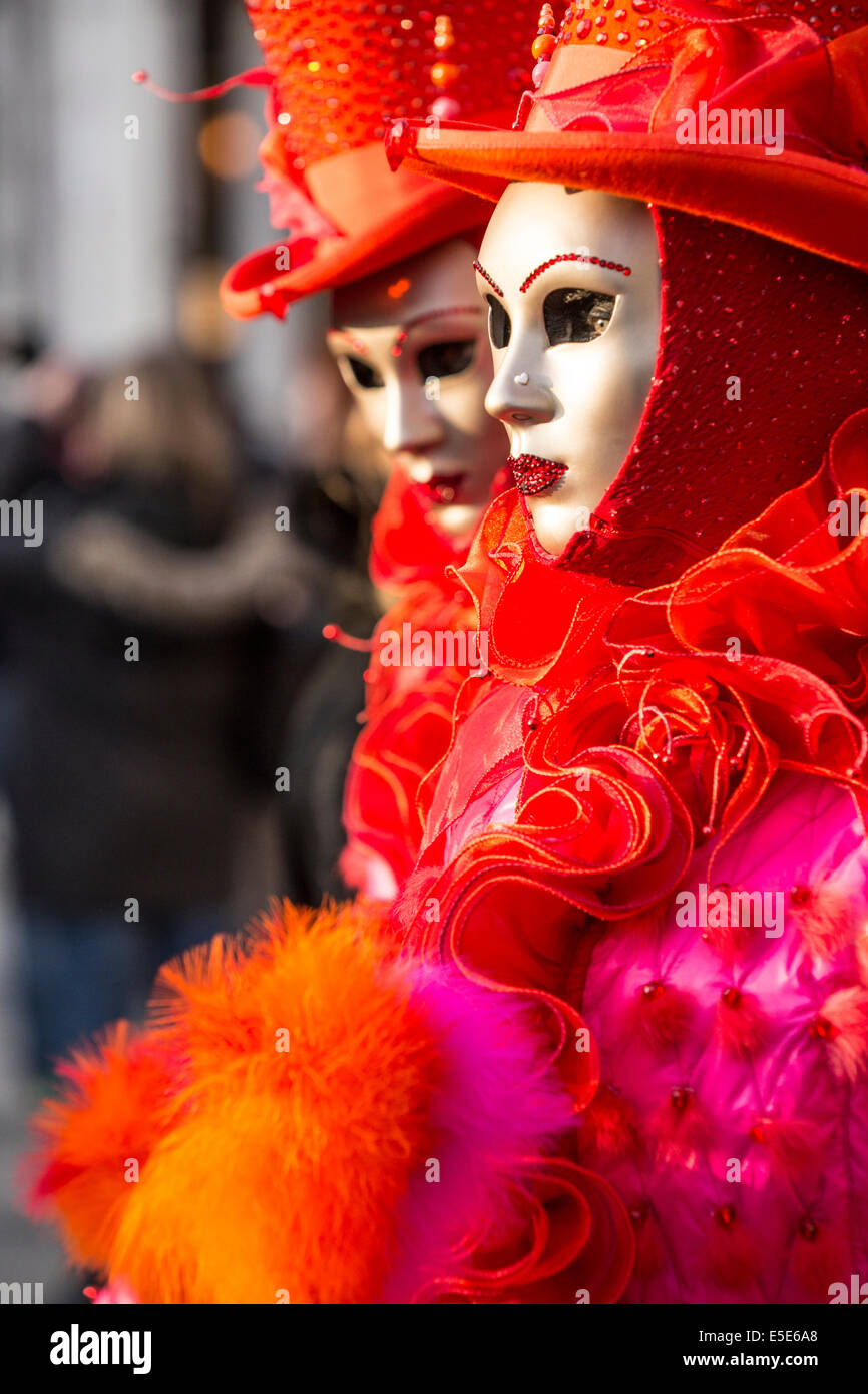 Rouge vif et costumes à froufrous ornent deux femmes à st. la place Saint-Marc à Venise pendant le carnaval. Banque D'Images