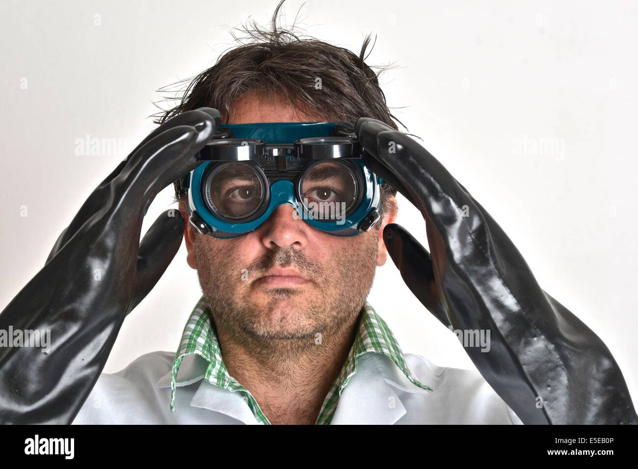 Scientifique fou portant une protection oculaire et des gants. Banque D'Images