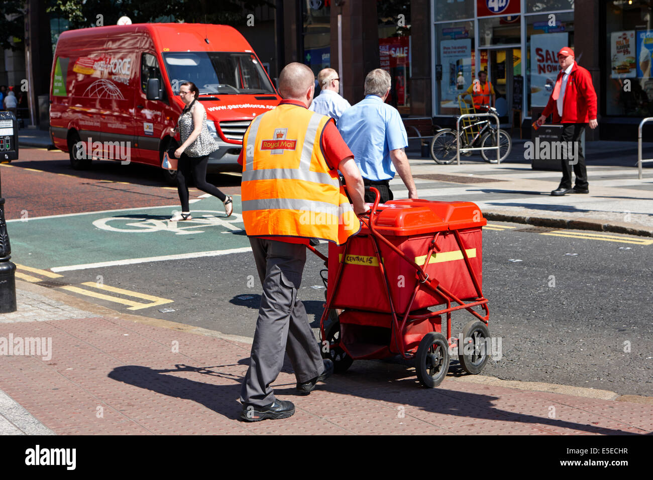 Royal Mail postman wheeling un panier de mail Belfast City Centre Banque D'Images