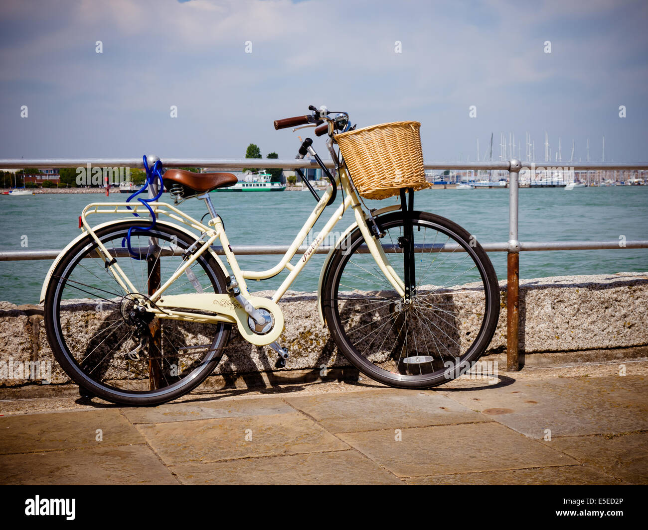 Un vélo appuyé contre les garde-corps par la mer Banque D'Images