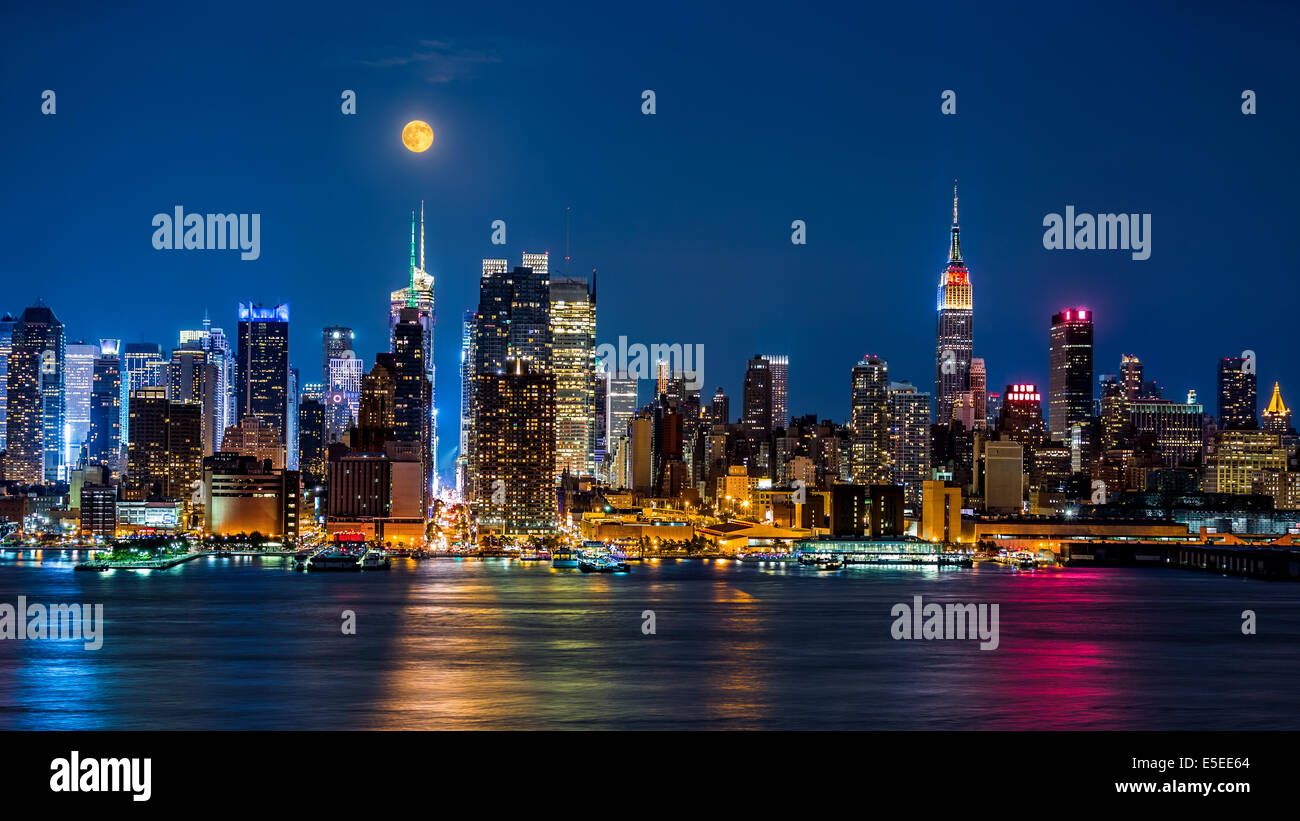 Super pleine Lune au-dessus de toits de New York. Banque D'Images