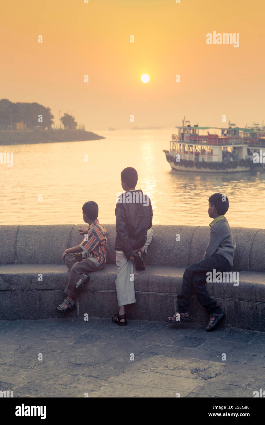 Les enfants à la recherche sur les docks de Mumbai à l'aube, Inde Banque D'Images