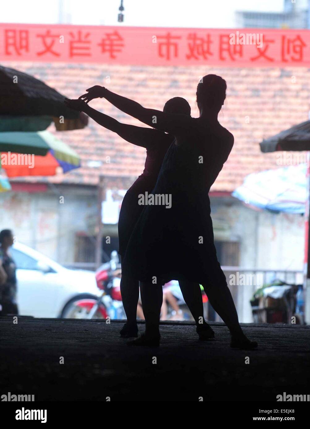 (140730) -- Paris, 30 juillet 2014 (Xinhua) -- concessionnaires femelle danse dans le passage d'Xiaoershan Marché aux Légumes à Liuzhou, Chine du Sud, région autonome Zhuang du Guangxi, le 27 juillet 2014. Les concessionnaires des femmes ici ont profité d'inactivité pour faire de l'exercice physique par la danse. (Xinhua/Huang Xiaobang) (lfj) Banque D'Images