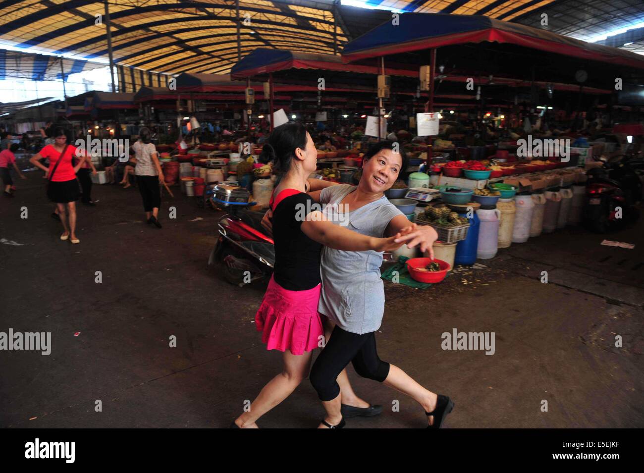 (140730) -- LIUZHOU, 30 juillet 2014 (Xinhua) -- concessionnaires femelle danse dans le passage de Qianjin à Liuzhou Marché du sud de la Chine, région autonome Zhuang du Guangxi, le 28 juillet 2014. Les concessionnaires des femmes ici ont profité d'inactivité pour faire de l'exercice physique par la danse. (Xinhua/Huang Xiaobang) (lfj) Banque D'Images