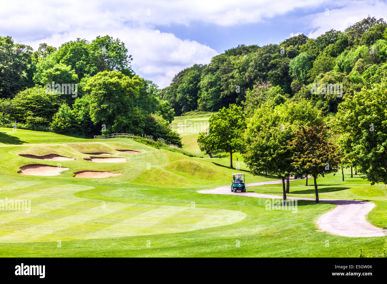 Bunkers, putting green et buggy sur un parcours de golf. Banque D'Images