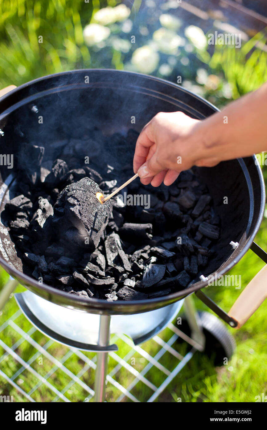 Trouver une allumette, brûler un charbon de barbecue, préparer pour la cuisson Banque D'Images