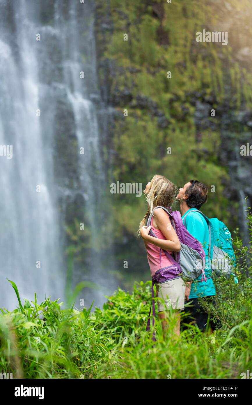Couple de s'amuser ensemble en plein air sur la randonnée à amazing waterfall à Hawaii. Banque D'Images