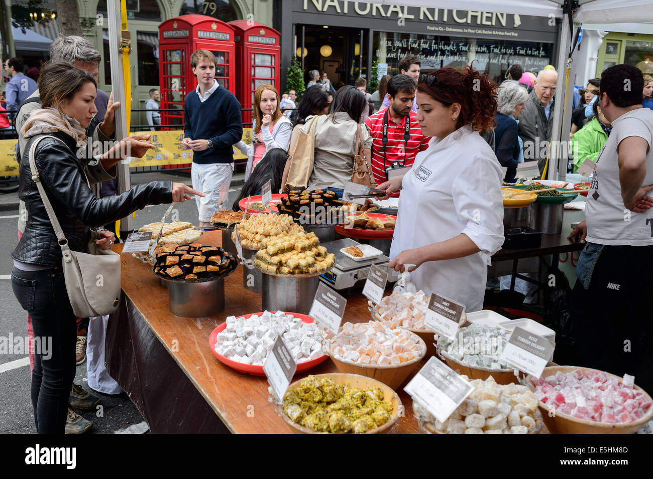 Le Moyen-Orient arabe/food, Marylebone Summer Street Fayre, Londres. Une jeune femme et son compagnon point à ce qu'ils veulent Banque D'Images