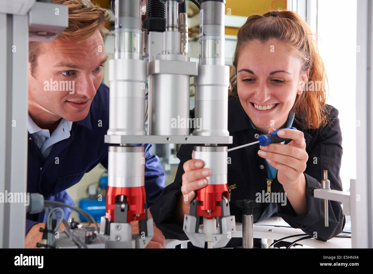 Apprenti ingénieur et de travailler sur la machine en usine Banque D'Images
