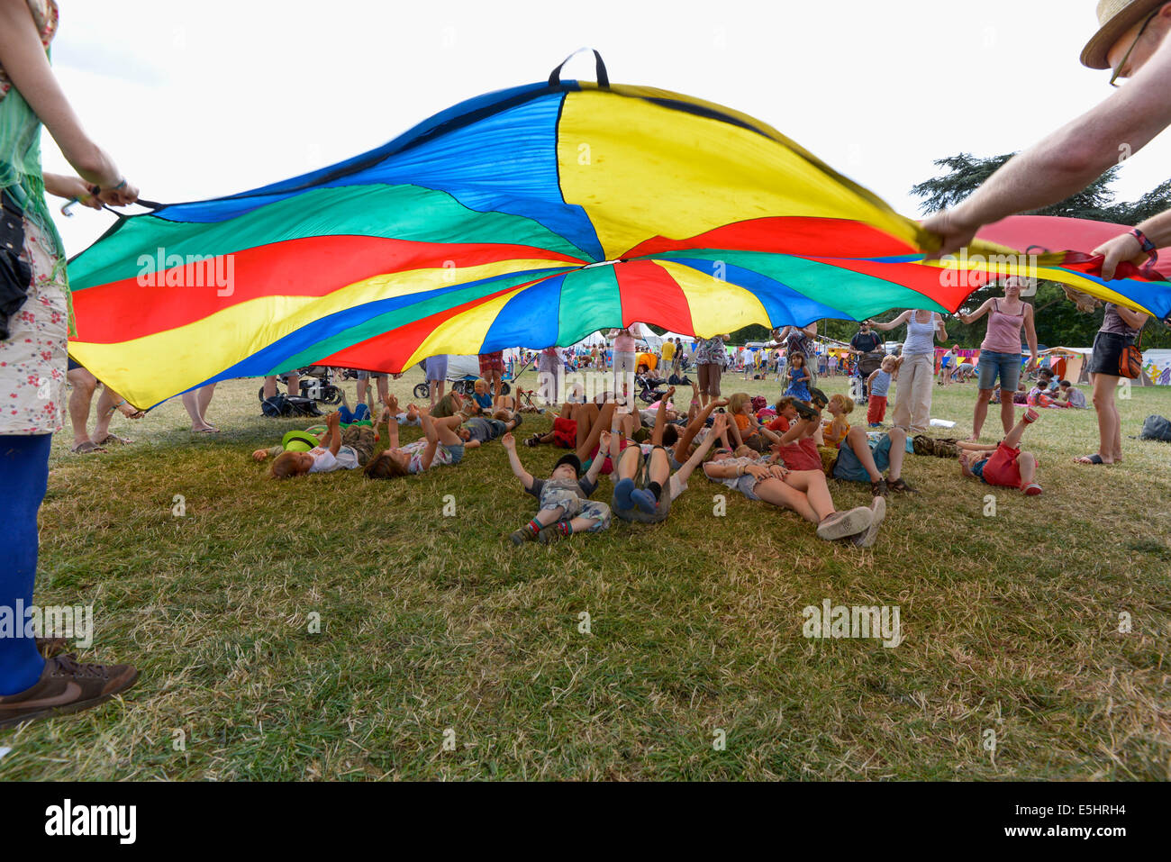 Malmesbury, UK, 27/07/2014 : Atmosphère au monde - WOMAD de la musique, des arts et de la danse. Chlidrens jeux sous un grand parachute dans l'espace pour enfants. Photo par Julie Edwards Banque D'Images