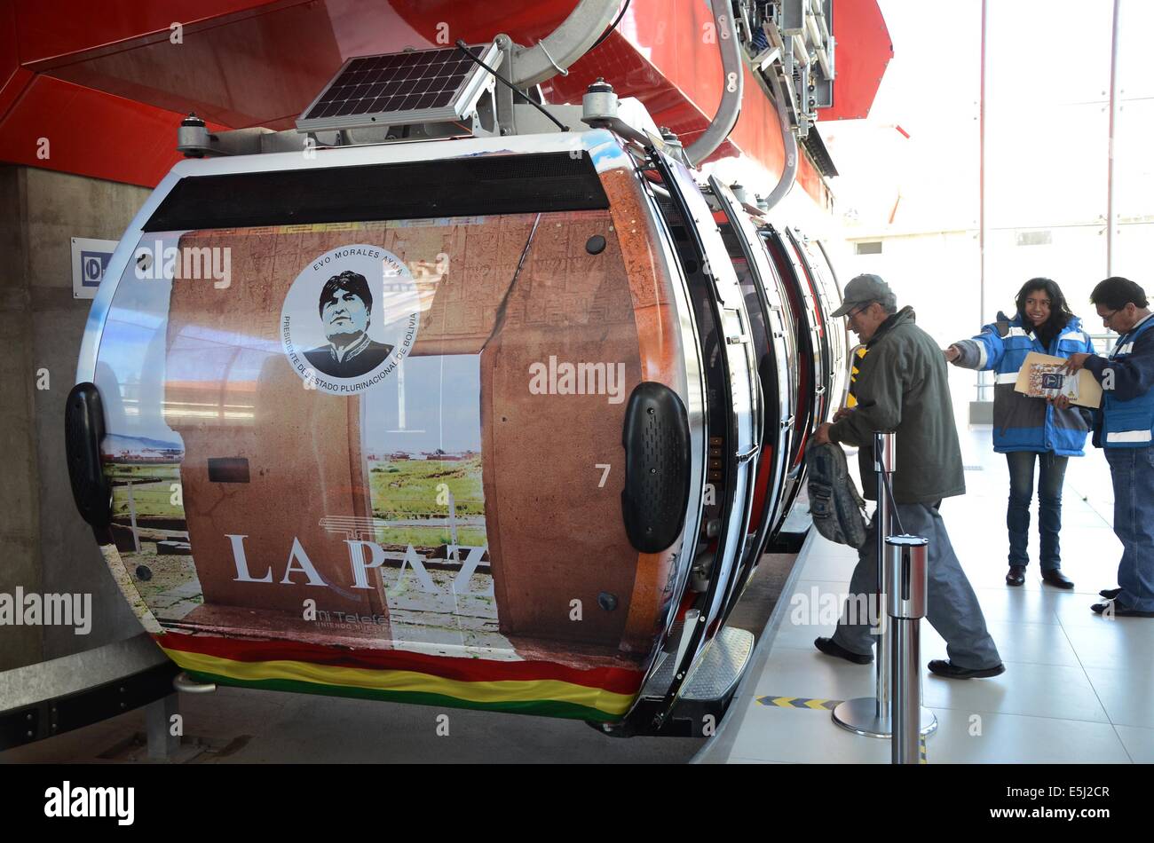 La Paz, Bolivie. 1er août, 2014. Un homme entre dans une cabine de la ligne rouge du La Paz-El Alto, recouvert d'une image représentative de la Bolivie, à El Alto, La Paz, Bolivie, le ministère le 1 août 2014. 10 remontées mécaniques ont été couverts avec des images représentatives de la Bolivie pour célébrer le Jour de l'indépendance de la Bolivie, qui est célébrée le 6 août. © Calrlos Barrios/ABI/Xinhua/Alamy Live News Banque D'Images