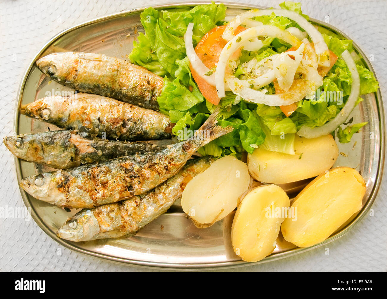 Sardines grillées avec salade méditerranéenne et des pommes de terre. Plat typique de la Méditerranée. Banque D'Images