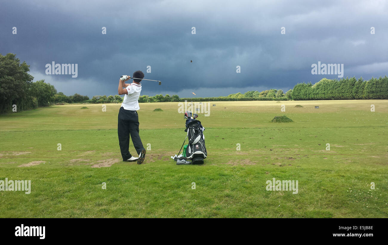 Bristol, Royaume-Uni. 2e août, 2014. Météo britannique. Jeune championne junior vu pratiquer comme approches Tempête sur de longues Ashton Golf Club près de Bristol. Crédit : Robert Timoney/Alamy Live News Banque D'Images