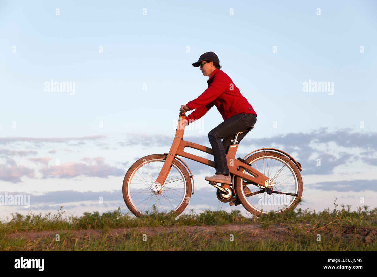 Pays-bas, Stavoren, Woman riding a Bike Bough. Le Dutch Design vélo en bois est une création de Jan Gunneweg Banque D'Images