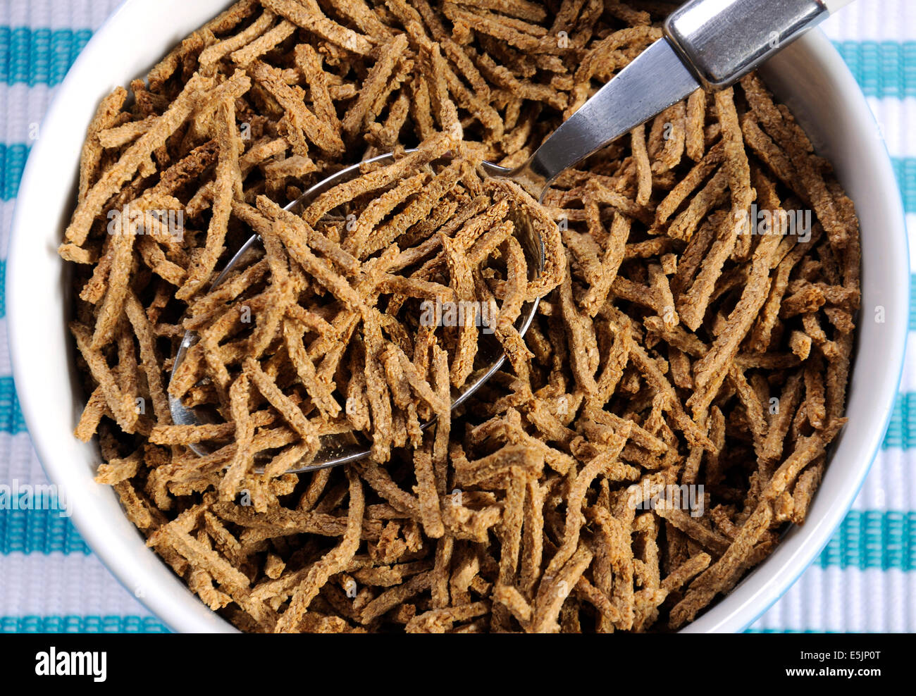 Saine alimentation élevée en fibres alimentaires avec petit déjeuner bol de céréales de son sur aqua bleu et blanc set de table - close up. Banque D'Images