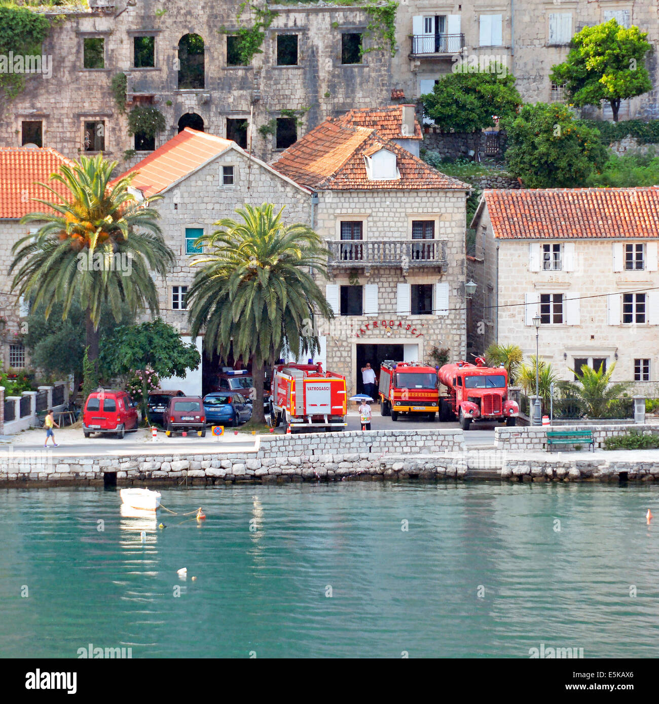 Caserne de pompiers de Perast village avec camion-moteur rouge ancien et moderne, stationnés le long de la baie de Kotor au Monténégro Banque D'Images