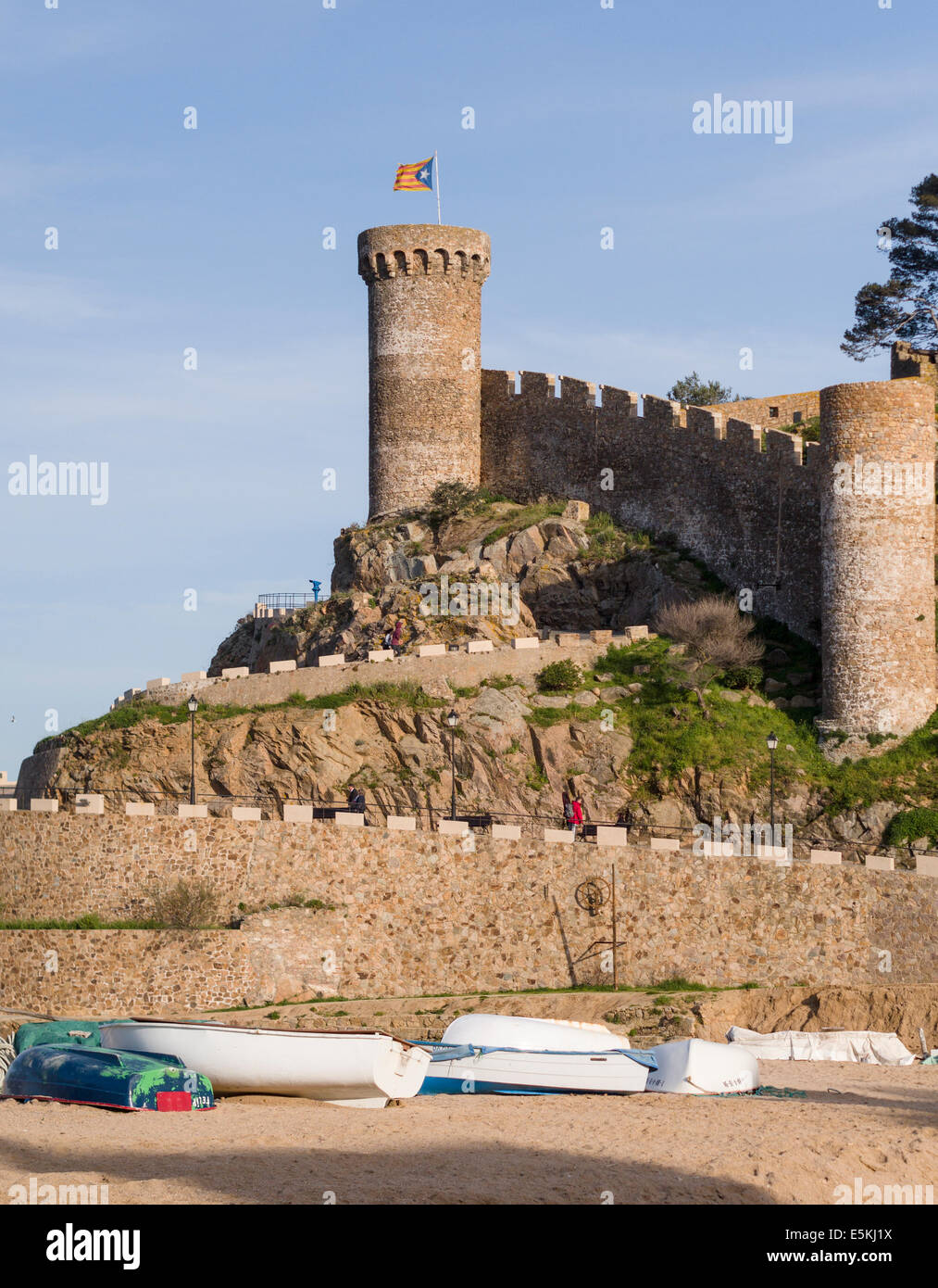 Forteresse de Tossa de Mar surmonté d'un drapeau catalan, bateaux ci-dessous. La muraille en pierre massive et tour de ce monument Banque D'Images