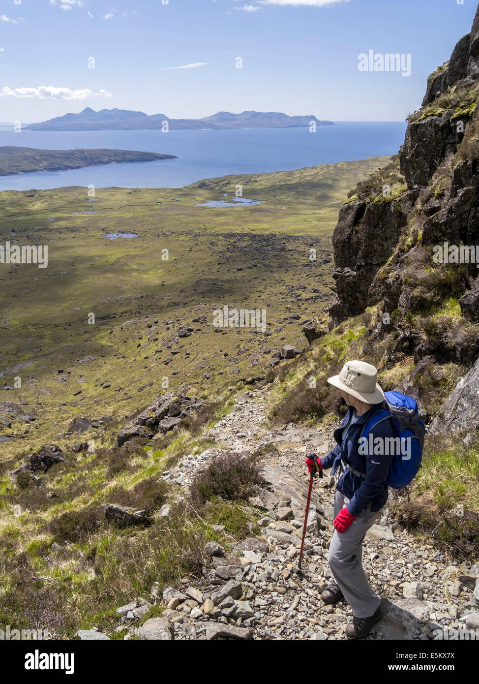 Seule femme walker hill haut sur un Ghrunnda Coco ascension dans les montagnes Cuillin avec Île de rhum en distance, Skye, Ecosse, Royaume-Uni Banque D'Images