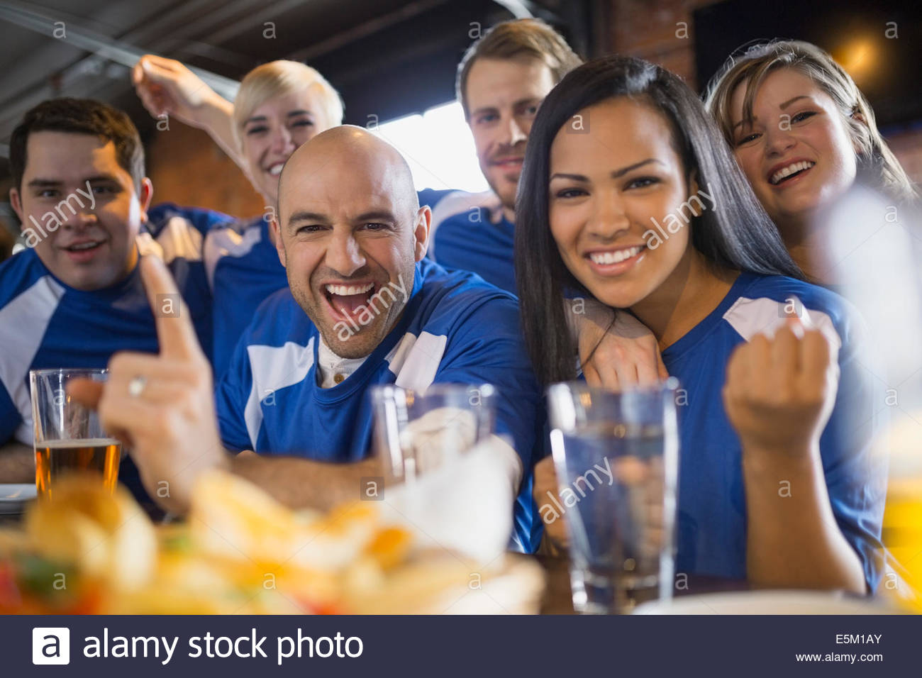 Les fans de sport cheering in pub Banque D'Images