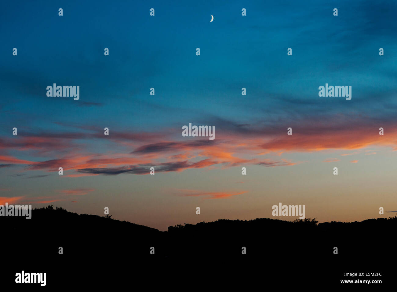 Photo Lune Pix Ville Pays Une nouvelle lune se coucher dans les vestiges d'un spectaculaire coucher de soleil, au-dessus de la ville de Presteigne, au milieu du pays de Galles, au Royaume-Uni Photo Stock - Alamy