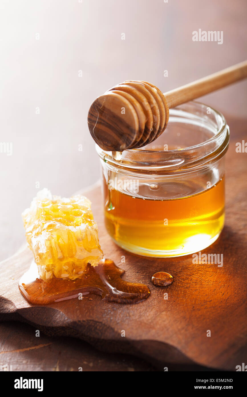 Balancier d'abeilles et du miel en pot sur fond de bois Banque D'Images