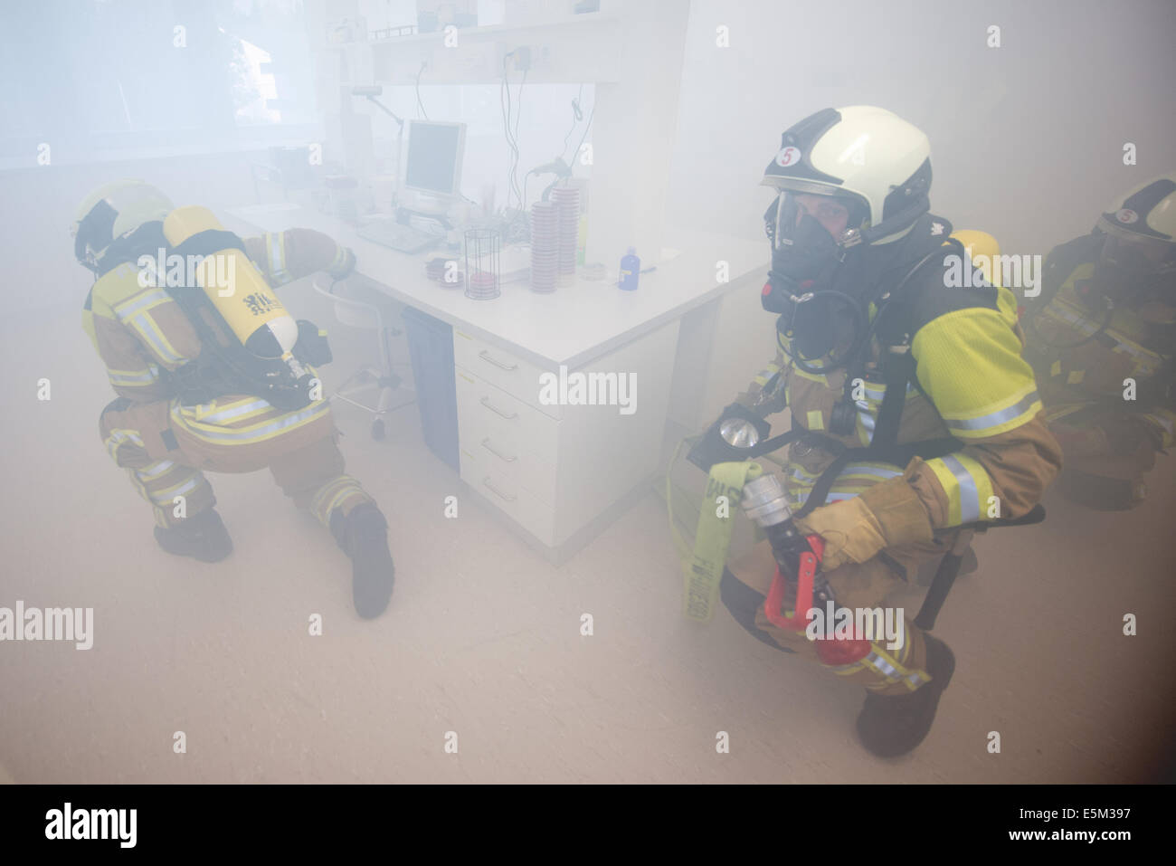 Dresde, Allemagne. Le 04 août, 2014. Les pompiers de Dresde arrive pour un exercice d'urgence le service d'incendie dans un laboratoire du centre de soins de médecine du travail de Dresde, Moebius Quasdorf GbR (MVZ) Dresden à Dresden, Allemagne, 04 août 2014. Douze camions incendie avec environ 40 soldats du feu sont arrivés avec un véhicule de décontamination pour simuler le sauvetage d'une personne infectée par la tuberculose. Photo : Arno Burgi/dpa/Alamy Live News Banque D'Images