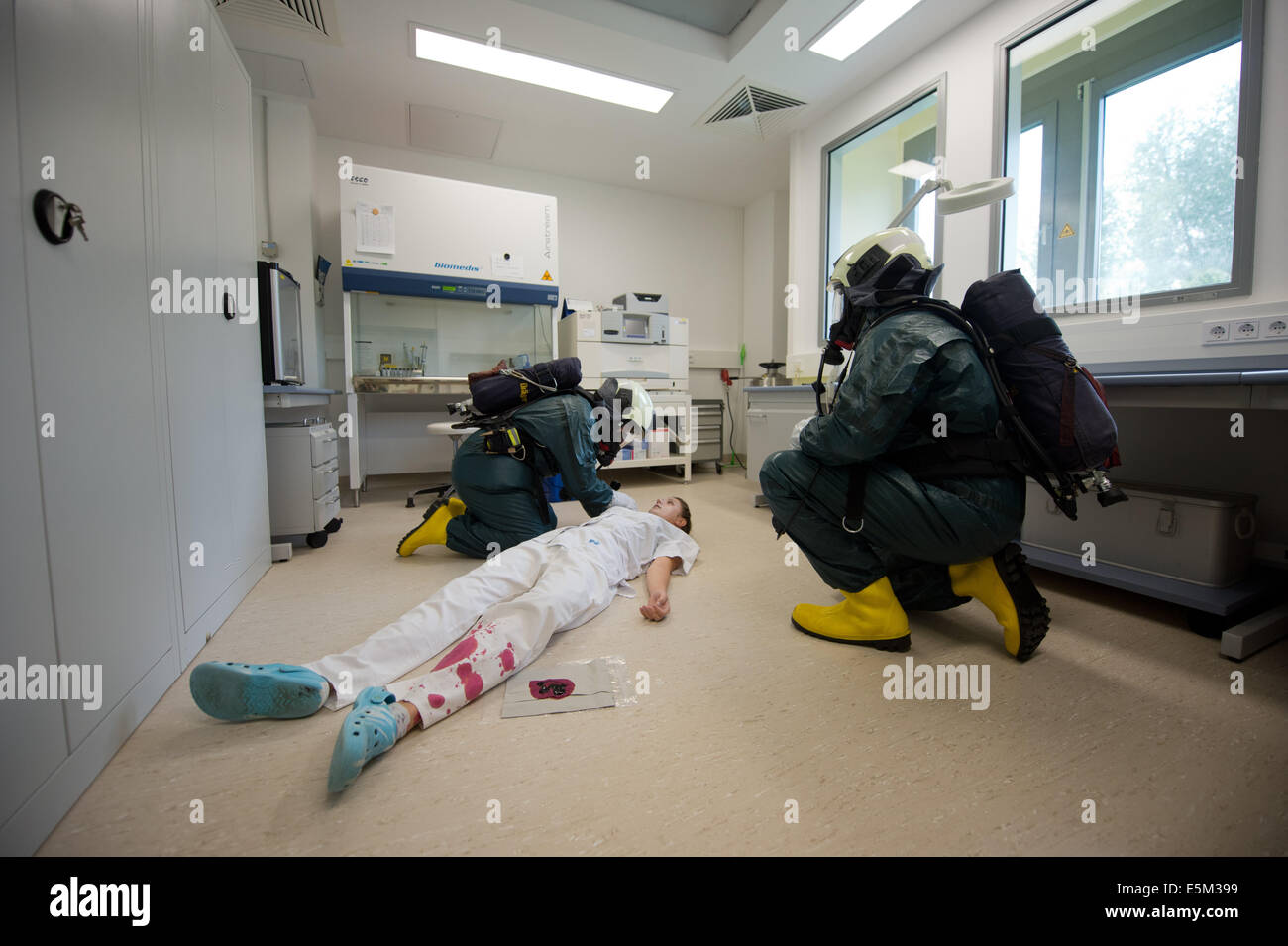 Dresde, Allemagne. Le 04 août, 2014. L'assistant technique médical (MTA) Sindy Leibelt, c'est "scued' par les pompiers en cas d'urgence l'exercice d'un service d'incendie dans un laboratoire du centre de soins de médecine du travail de Dresde, Moebius Quasdorf GbR (MVZ) Dresden à Dresden, Allemagne, 04 août 2014. Douze camions incendie avec environ 40 soldats du feu sont arrivés avec un véhicule de décontamination pour simuler le sauvetage d'une personne infectée par la tuberculose. Photo : Arno Burgi/dpa/Alamy Live News Banque D'Images