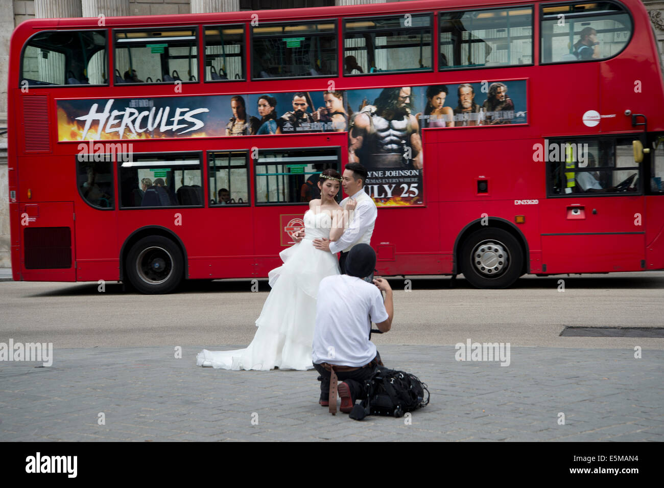 Prendre des photos de mariage japonais en face de la cathédrale St Paul et la publicité London bus rouge film Hercules Banque D'Images