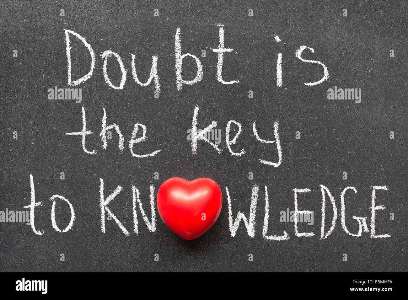 Le doute est la clé de l'expression de la connaissance à la main sur tableau noir avec le symbole de coeur au lieu d'O Banque D'Images