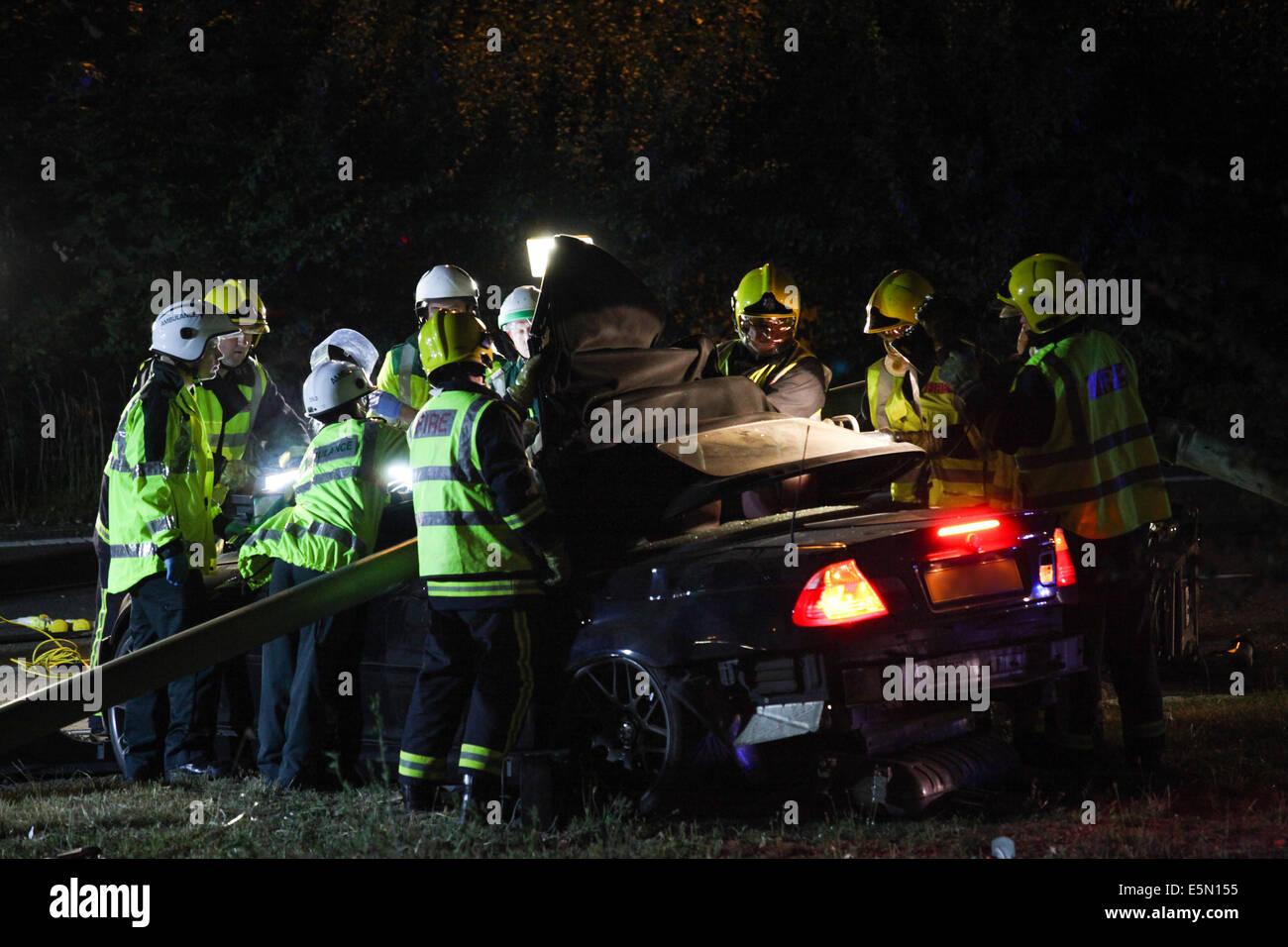 Les services d'urgence tentative de libérer un homme de sa BMW M3, qui s'est écrasé dans un grand lampadaire sur le côté de la route Banque D'Images Les services d'urgence tentative de libérer un homme de sa BMW M3, qui s'est écrasé dans un grand lampadaire sur le côté de la route Banque D'Images