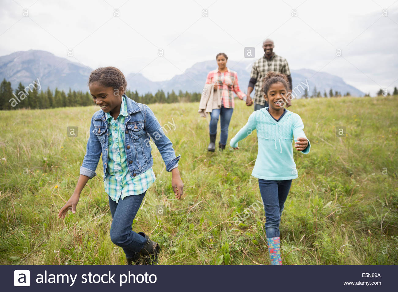 Family walking in grassy field Banque D'Images