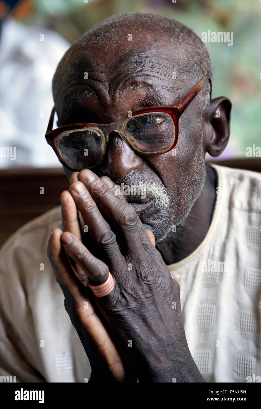 Vieil homme priant pendant le service du dimanche dans une église catholique, dans le Kuru, Nigéria Banque D'Images