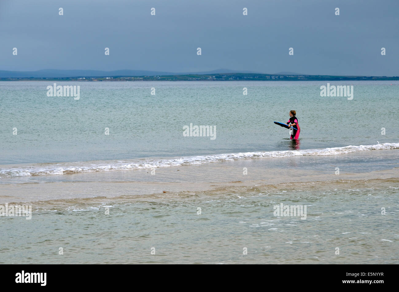 Un internaute attend en vain une vague sur une mer calme, Silver Strand, l'île d'Achill, Comté de mai, l'Irlande. Banque D'Images