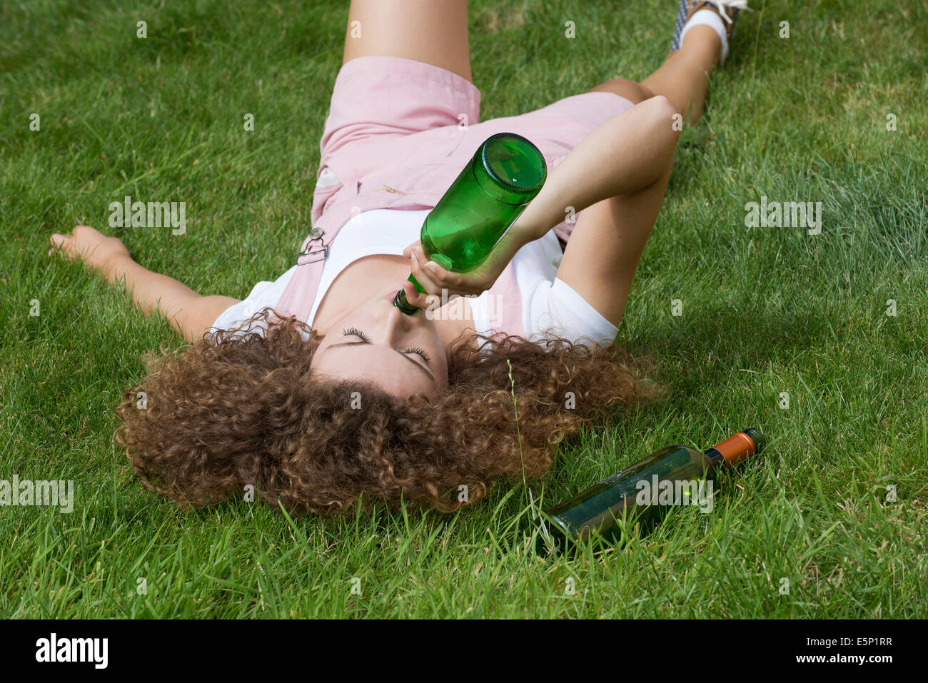 Problème d'alcool chez les adolescentes des boissons à partir de la fille une bouteille de bière Banque D'Images