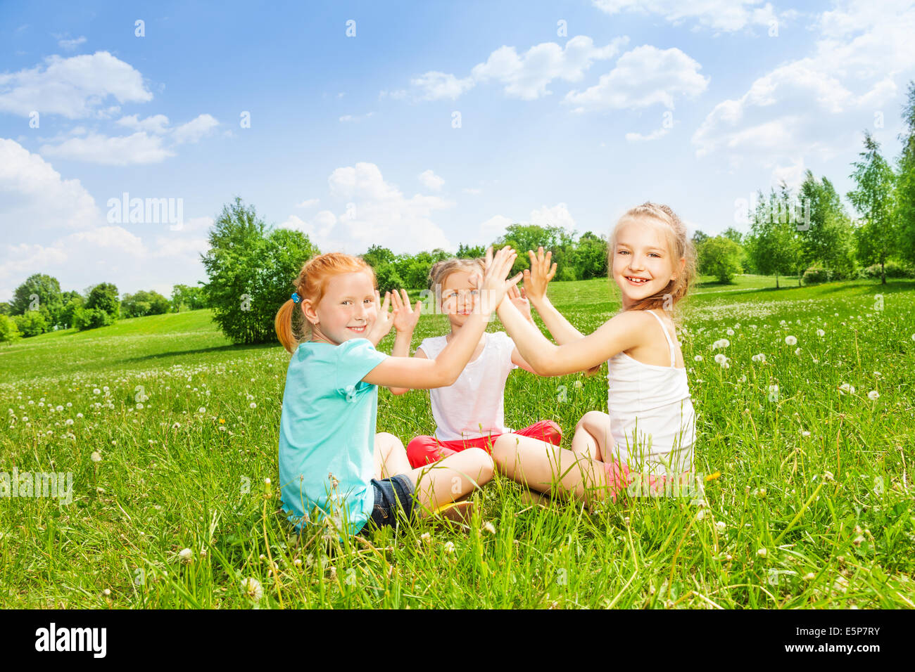 Trois enfants jouant sur une herbe Banque D'Images