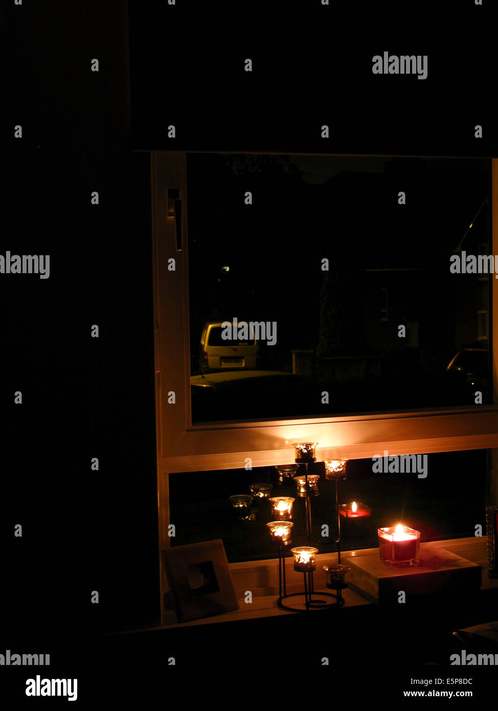 Glasgow Ecosse 4 août 2014. Des bougies allumées dans la fenêtre de la chambre dans le cadre de la commémoration de 100 ans depuis le début de la PREMIÈRE GUERRE MONDIALE. Maisons dans l'obscurité au-delà de la rue. Banque D'Images
