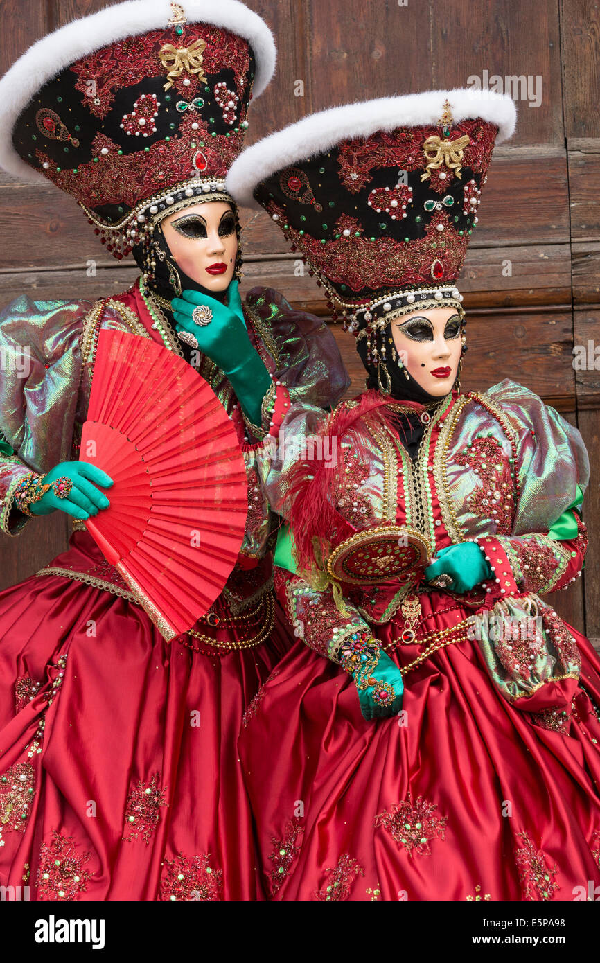 Paire de femmes dans l'élaboration de costumes stylisés vert rouge avec en face de la porte de l'église San Zaccaria pendant le carnaval de Venise Banque D'Images