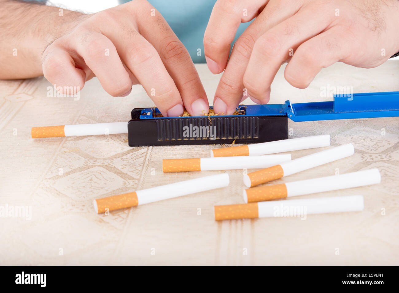 Les mains des hommes le roulement d'un cigarette à l'aide d'un papier collant ou rollings avec tabac frais moulu Banque D'Images Les mains des hommes le roulement d'un cigarette à l'aide d'un papier collant ou rollings avec tabac frais moulu Banque D'Images