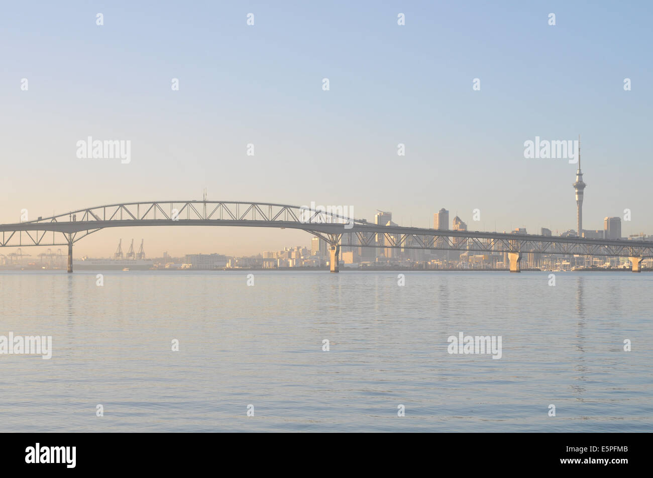 Vue sur Auckland Harbour Bridge de Birkenhead wharf in early morning light avec la CDB en arrière-plan Banque D'Images