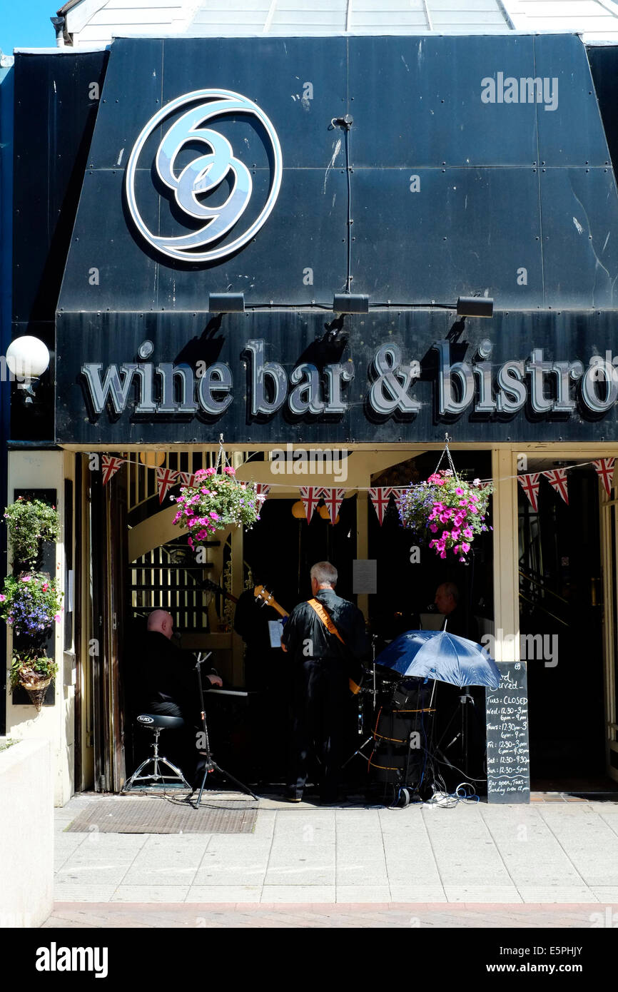 Groupe de musiciens jouer à un auditoire dans un bistro à la façade ouverte sur une chaude journée ensoleillée palmerston road uk angleterre southsea Banque D'Images