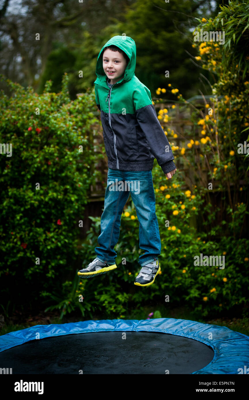 Anorak garçon en sautant sur le trampoline Banque D'Images