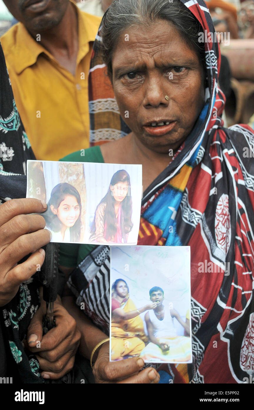 Mawa, le Bangladesh. 5e août, 2014. Une femmes du Bangladesh montre des images de ses parents disparus comme l'équipe de secours continue à chercher l'emplacement dans l'eau un jour après l'accident de ferry sur la rivière Padma dans le district de Munshiganj, quelque 37 km de la capitale Dhaka, Bangladesh, le 5 août 2014. Environ 28 heures après l'accident est survenu, le Bangladesh sauveteurs impossible de trouver aucune trace de l'épave du ferry qu'ils ont été confrontés à de graves difficultés en raison de hautes vagues et des vents forts. Shariful Islam Crédit :/Xinhua/Alamy Live News Banque D'Images