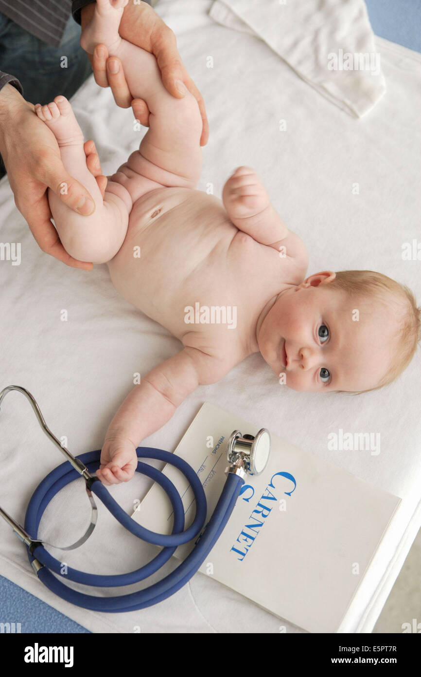 Pédiatre examinant le bassin de 2-month-old baby girl à la luxation congénitale de la hanche de l'écran. Banque D'Images